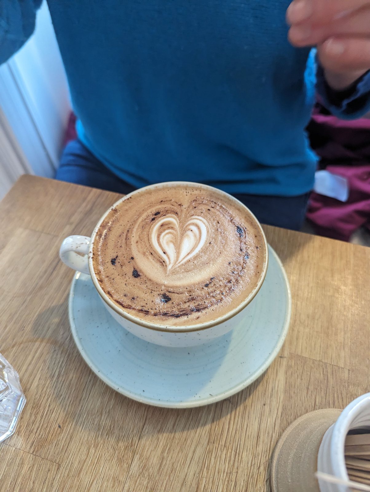 A cappuccino on the table in a harbour cafe at St Monans.