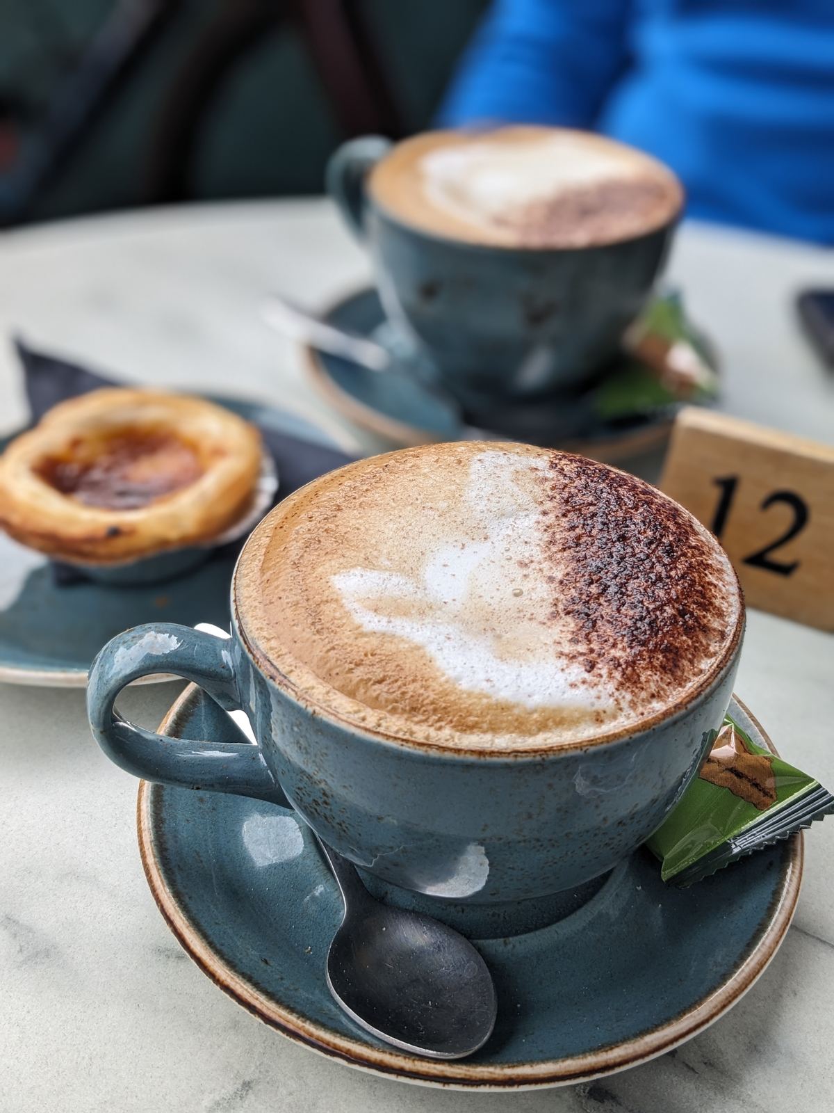 A frothy cappuccino with a leaf pattern in the foam on a café table in Stirling.