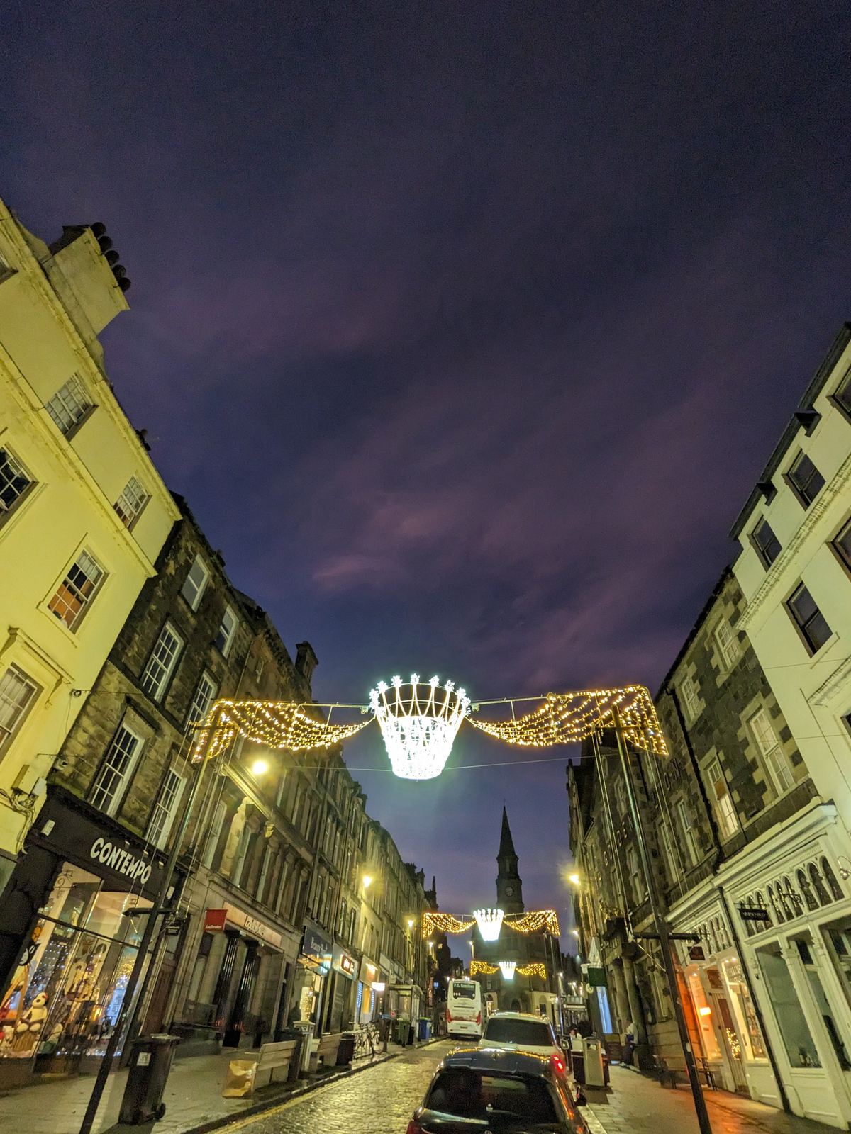 Stirling's old town street strung with Christmas lights glowing in the blue dusk, historic buildings on either side.