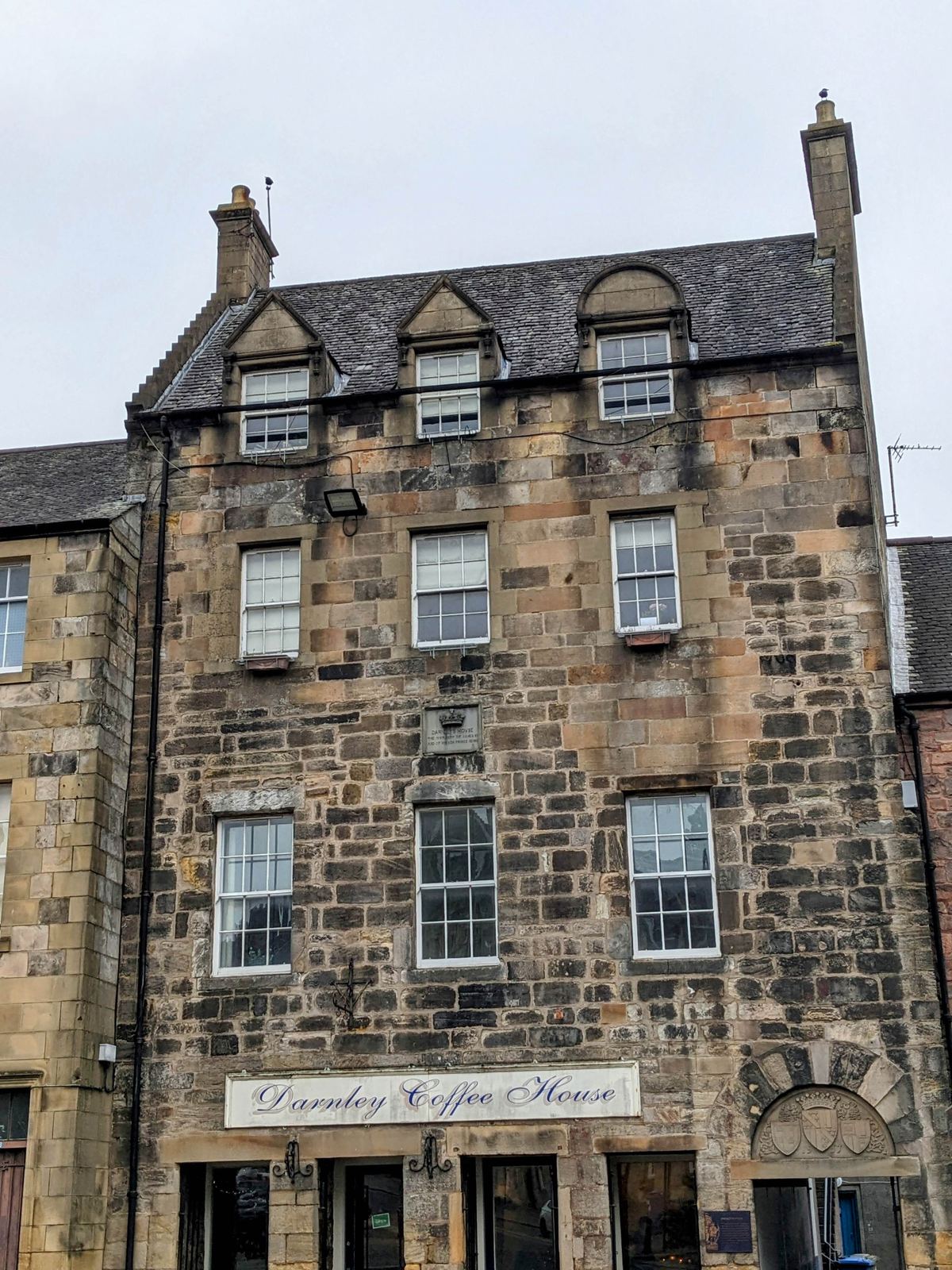 Tall historic stone tenement buildings lining a street in Stirling's old town.