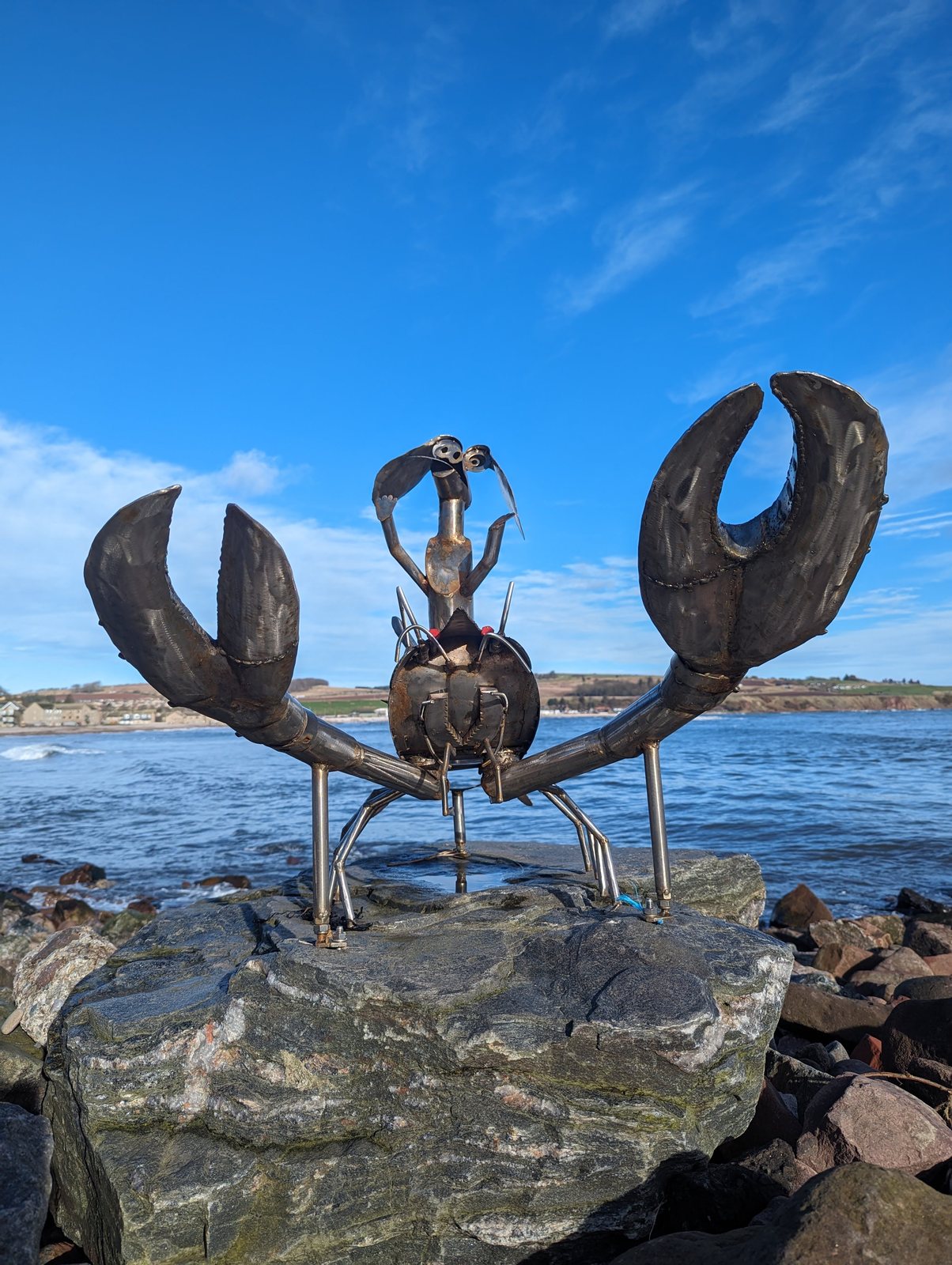 A giant metal crab sculpture on the rocks at Stonehaven.