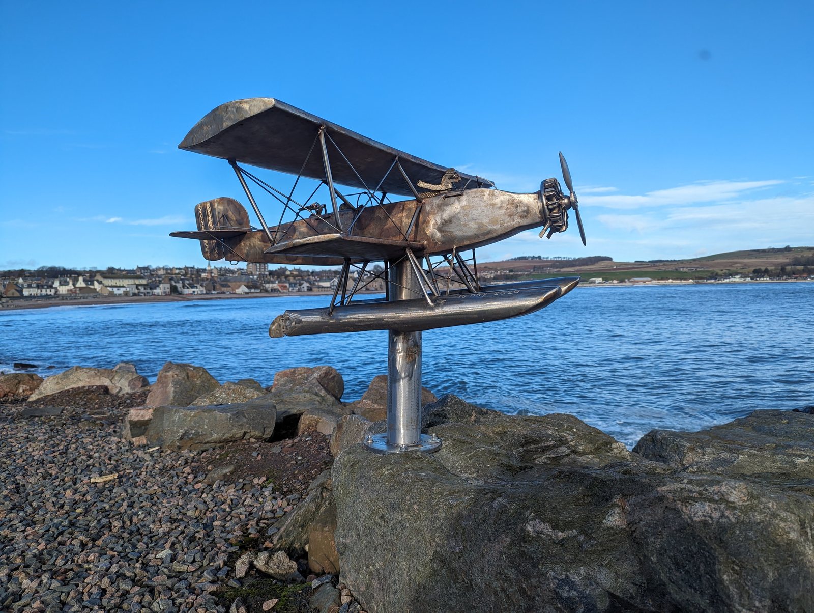 A biplane floatplane sculpture against the sky at Stonehaven.