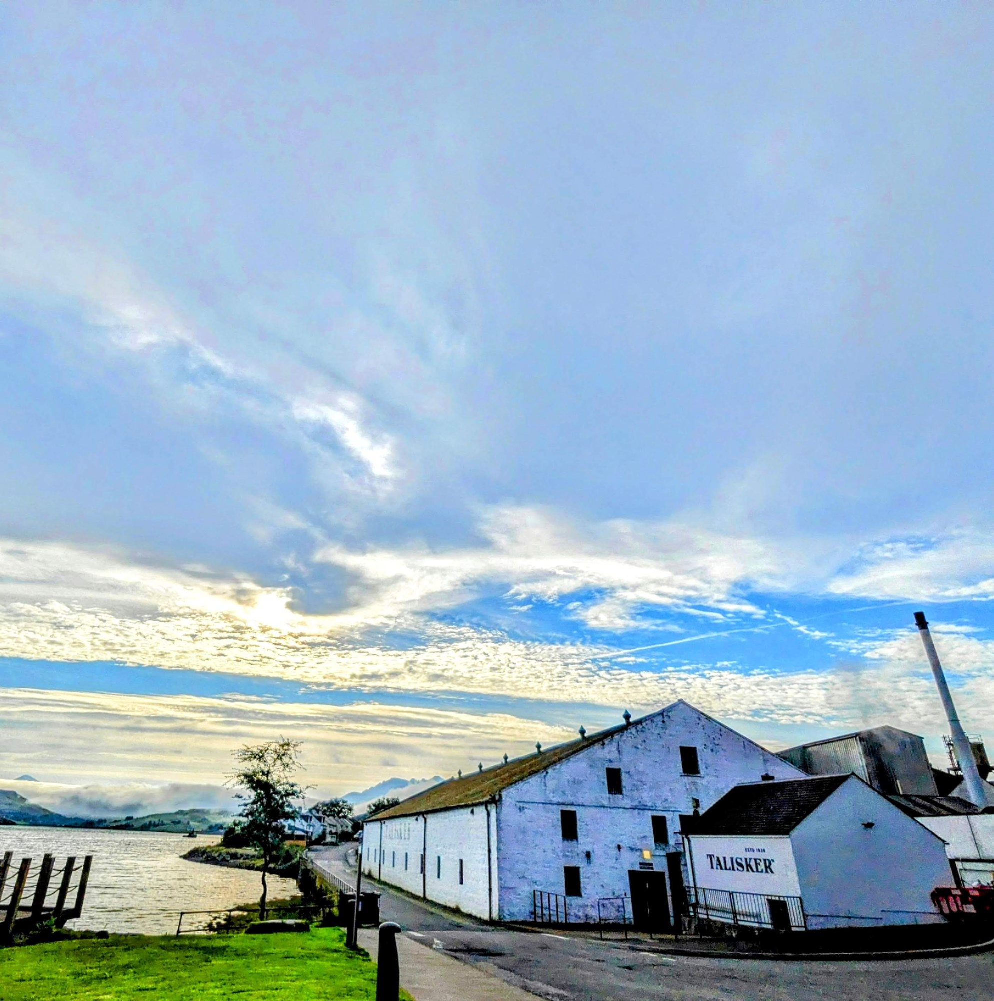 The white buildings of Talisker Distillery on the shore of Loch Harport, Skye.