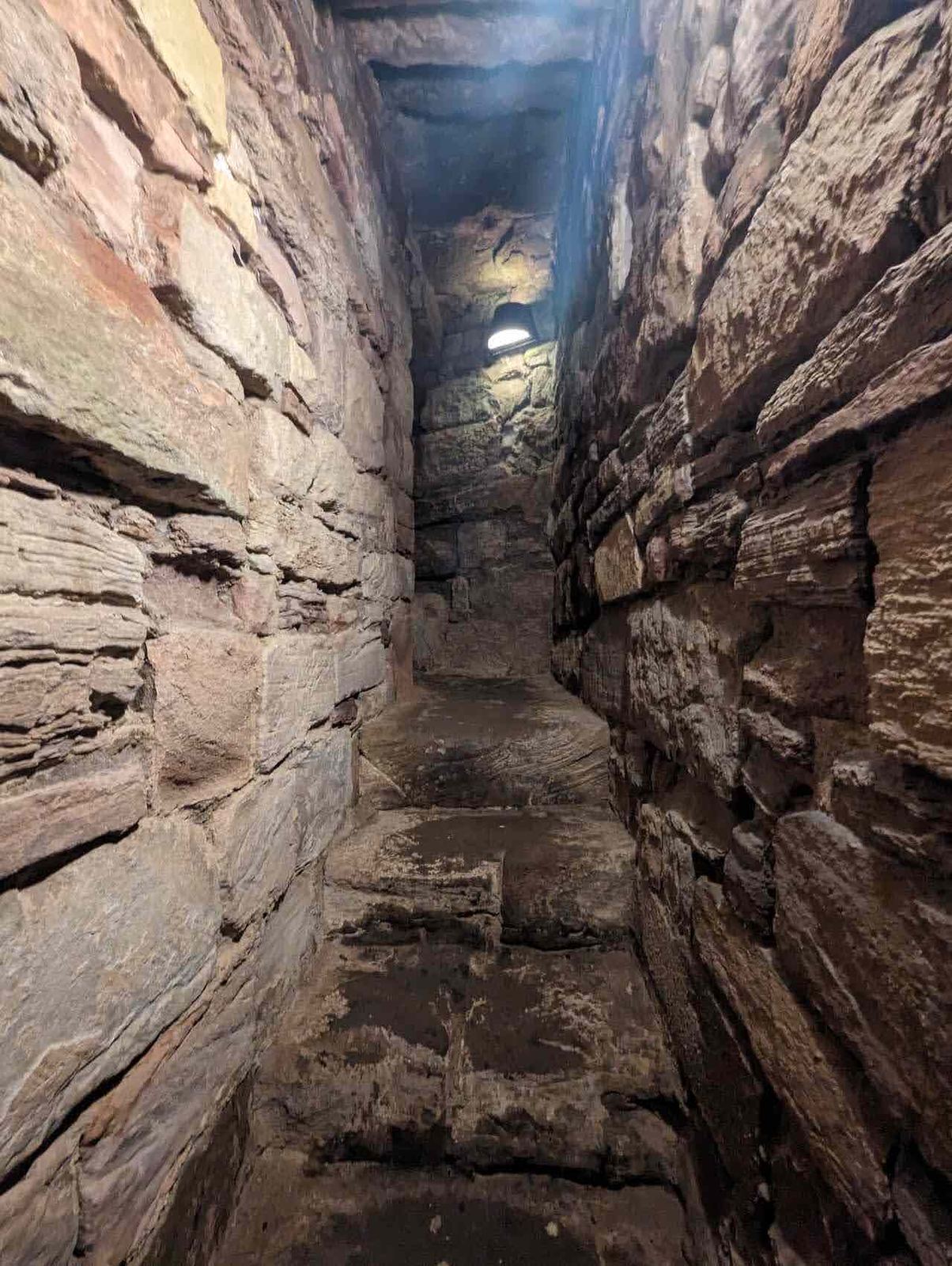 A worn spiral staircase inside a tower at Tantallon Castle.