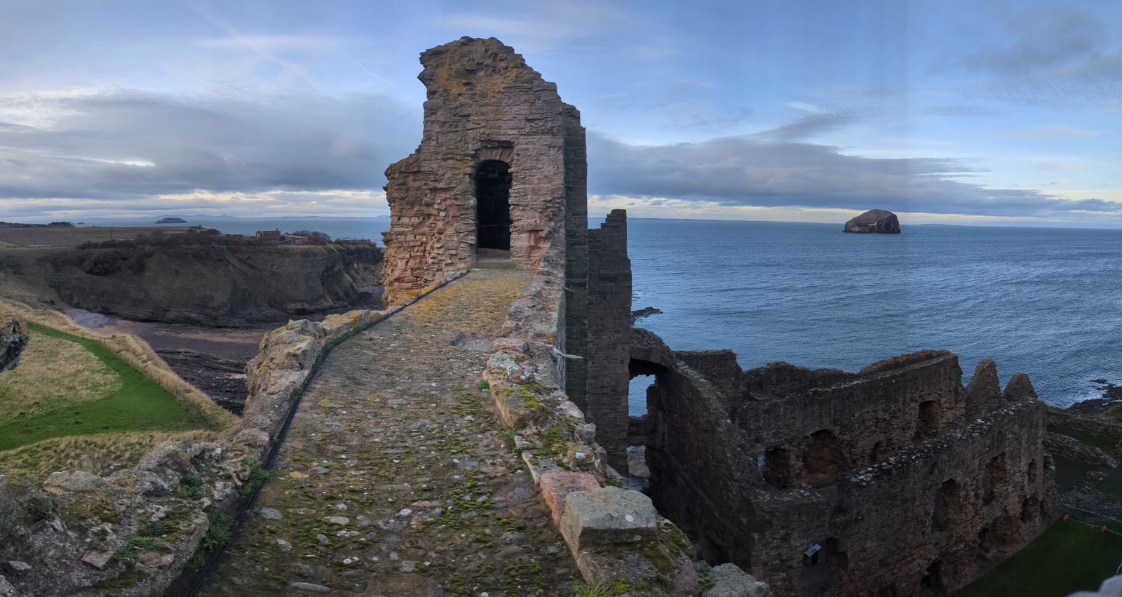 A lit vaulted stone passage within the walls of Tantallon Castle.