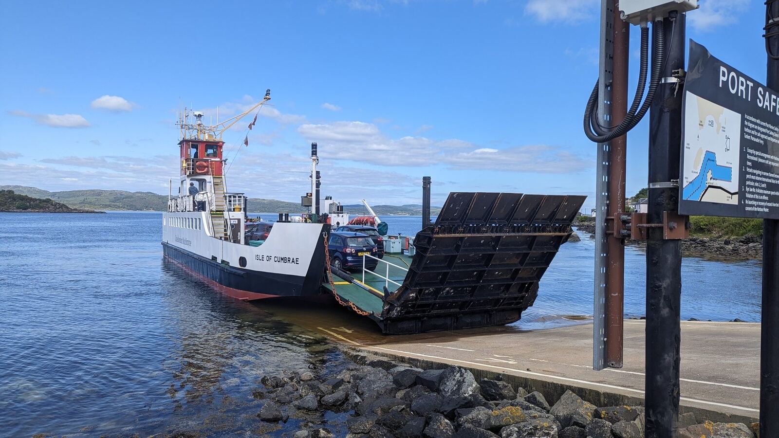 The Isle of Cumbrae ferry at the Tarbert slipway with its ramp down for loading, the Portavadie sign alongside.