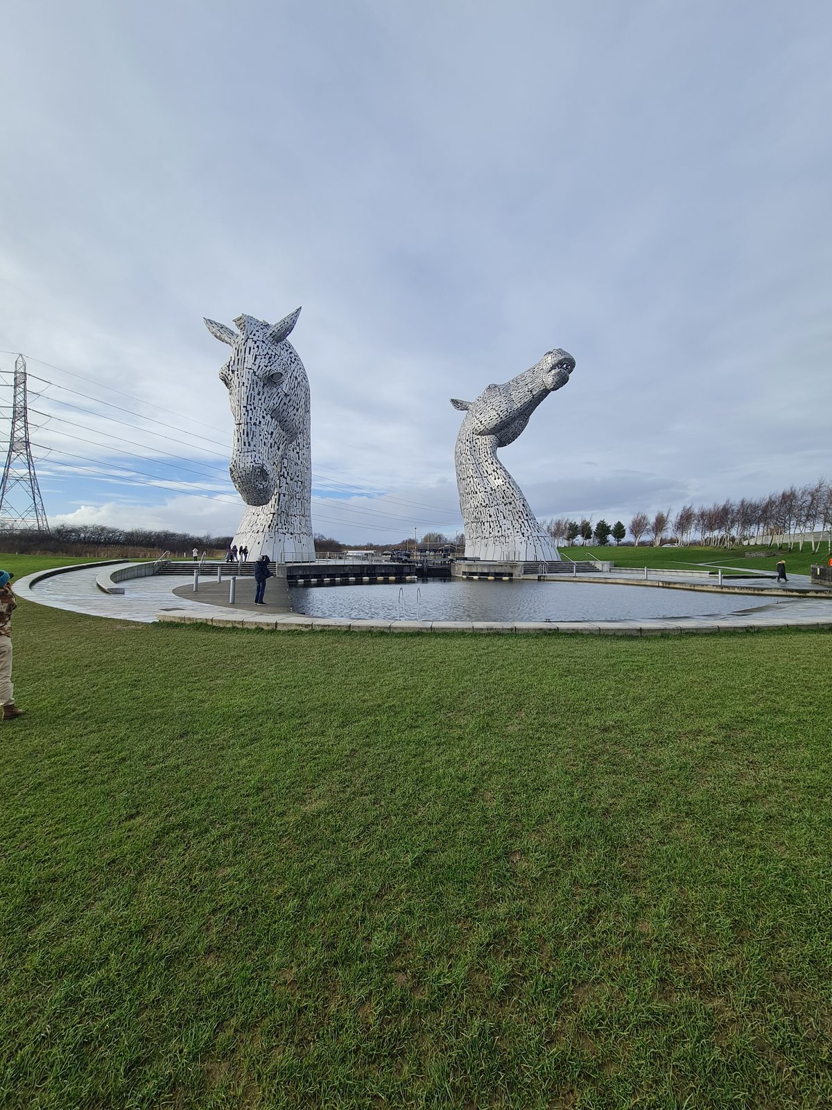 A person dwarfed beneath the Kelpies.